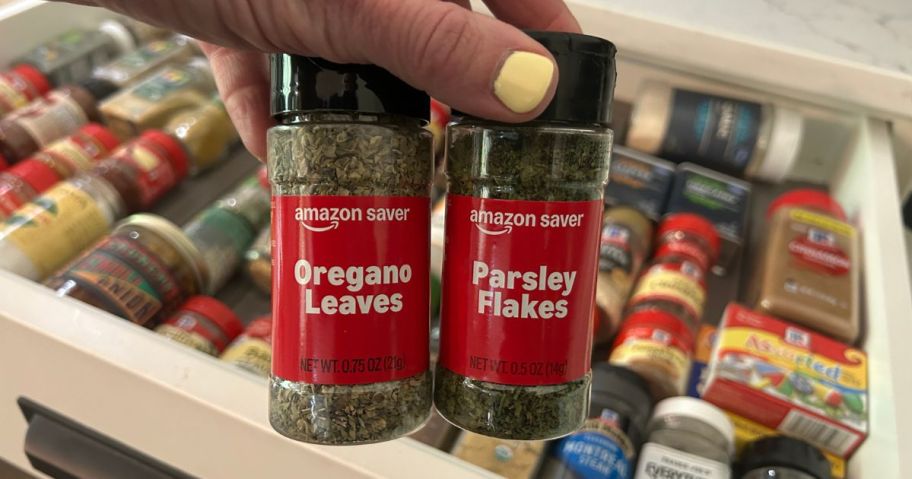 Hand holding two bottles of Amazon Saver Orgenao and Parsely