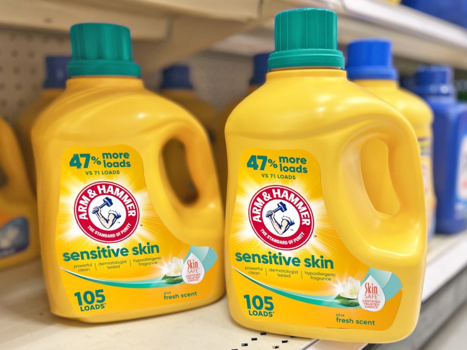 large yellow bottles of Arm & Hammer Sensitive Laundry Detergent on store shelf