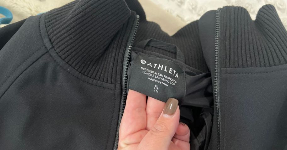 hand showing the tag on an Athleta Jacket