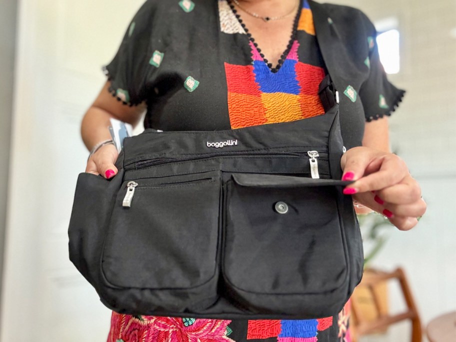 Woman holding black Baggallini purse