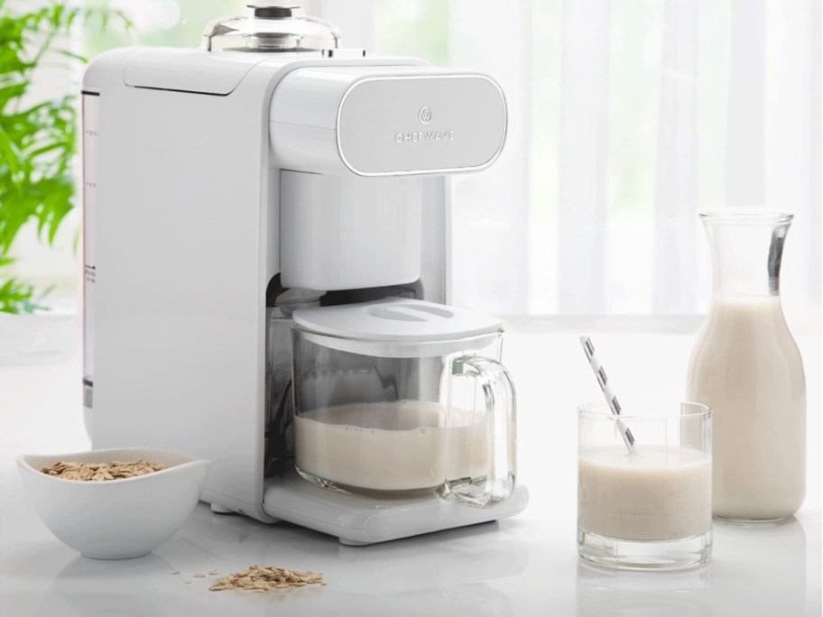 A nut milk maker machine on a kitchen counter.