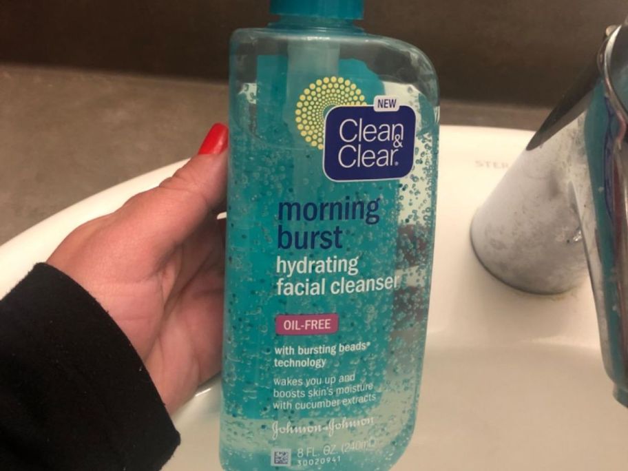 Hand holding a bottle of Clean & Clear Morning Burst Cleanser