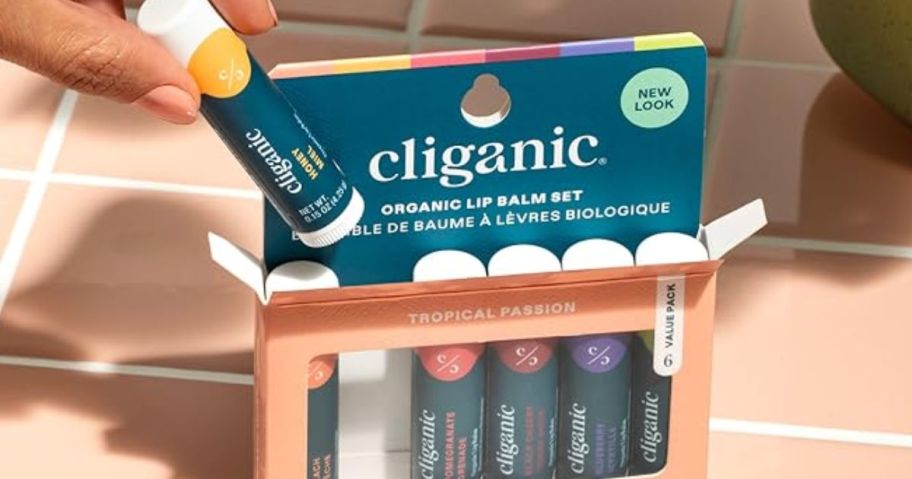 hand sticking lip balm out of its case 