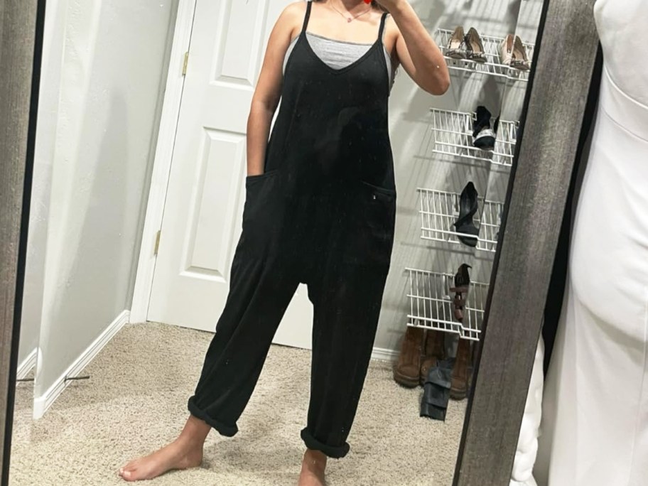 woman taking photo in a mirror wearing a black romper