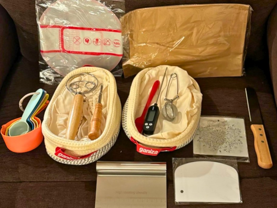 Complete sourdough bread starter kit with basket and utensils on table.