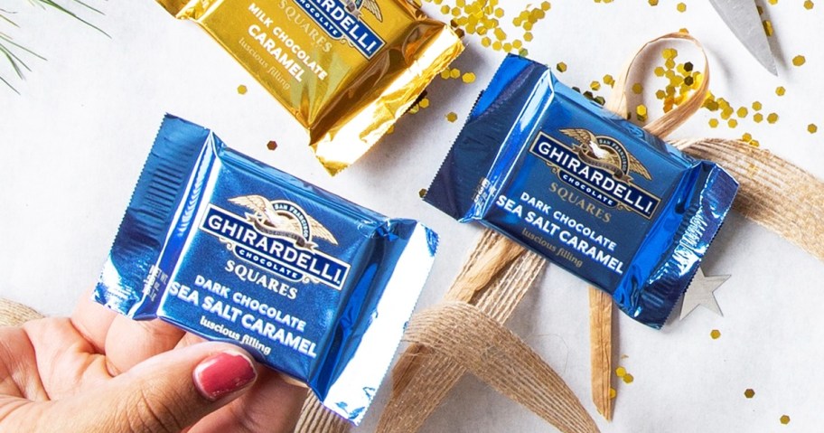hand holding blue Ghirardelli Dark Chocolate Sea Salt Caramel Square