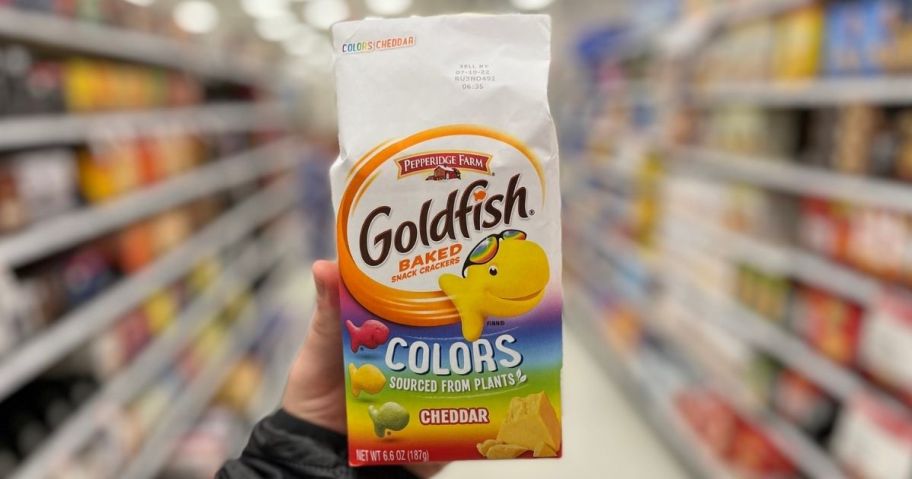 Hand holding a bag of Goldfish Crackers in Colors Cheddar Cheese Flavor