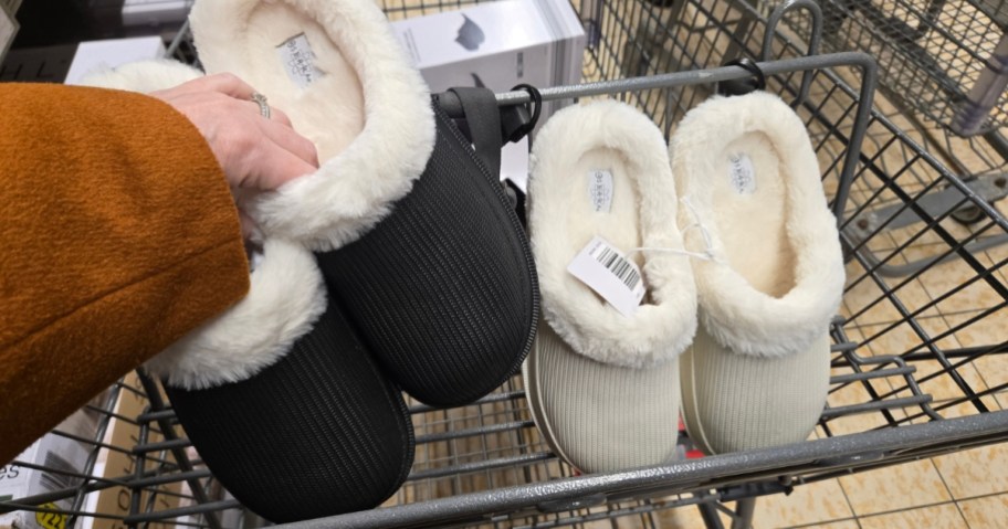 hand holding a pair of women's lined clogs, another pair in a cart next to it