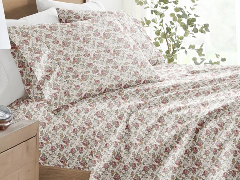 a bed with floral sheets on it