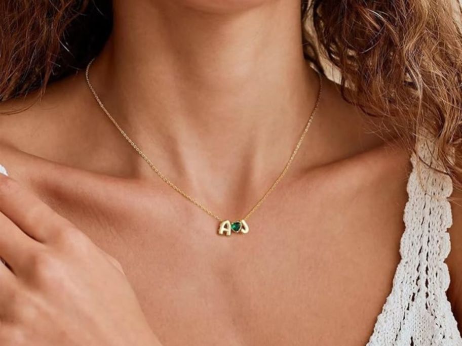 Woman wearing heart necklace with two initials