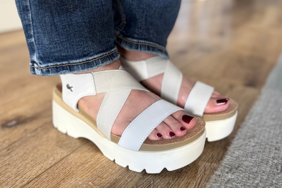 feet in white strappy sandals