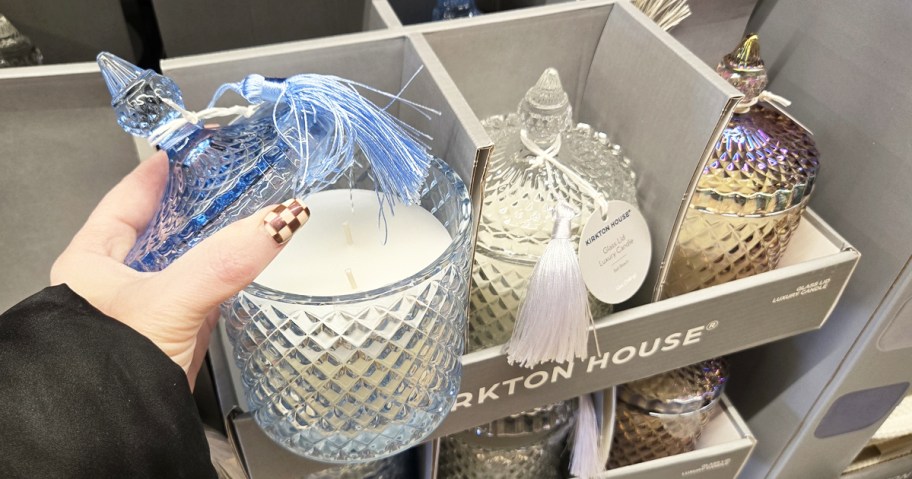 hand taking the lid off a glass jar candle