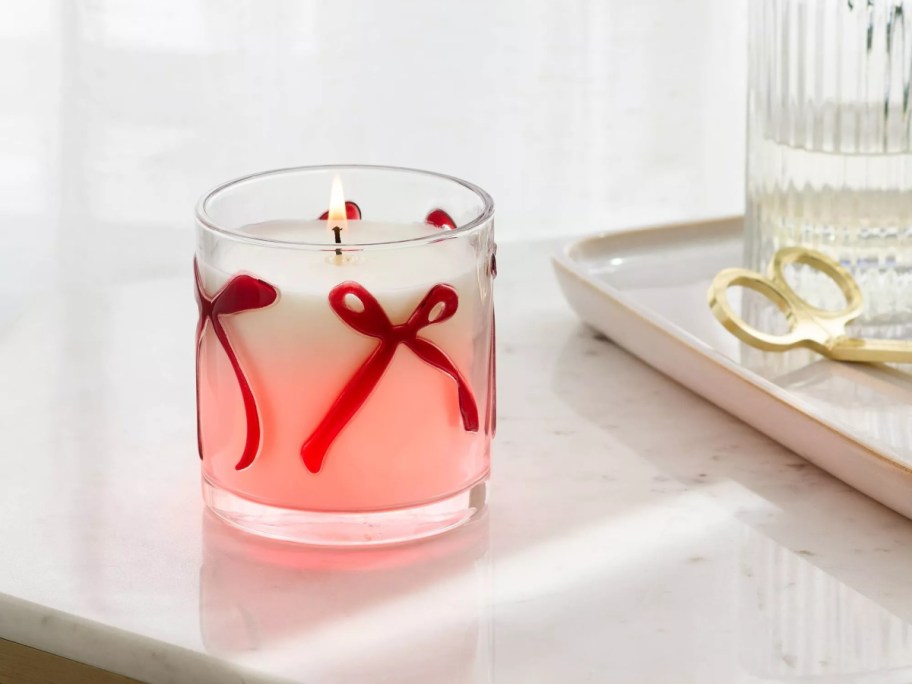 A glass candle with a red bow on it.