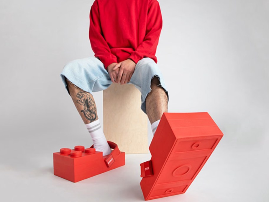 A man wearing red LEGO Crocs.