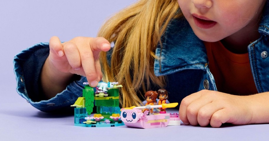 girl plaing with a LEGO Friends Axolotl Adventure Boat Building Toy set