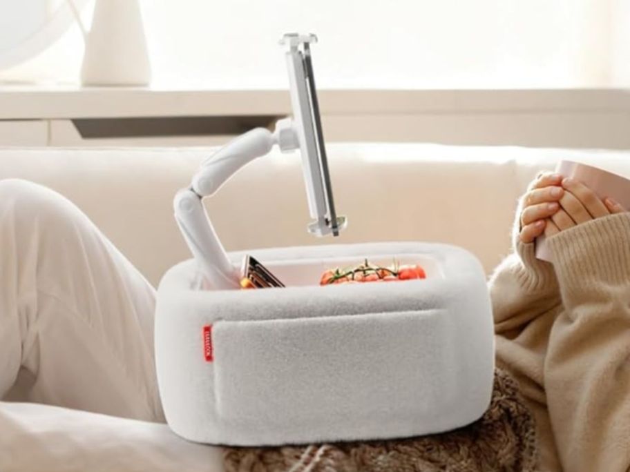 A person with a white fluffy tablet stand on their lap