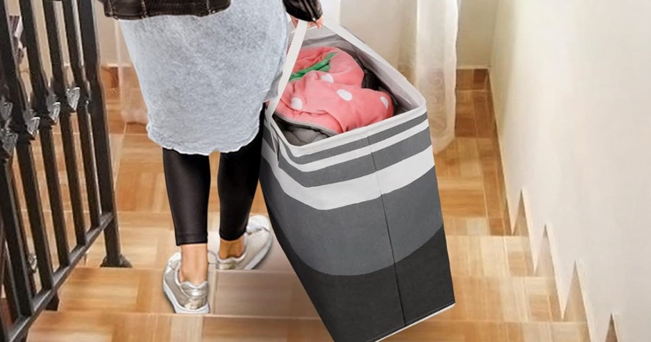 woman carrying one of the Laundry Hamper down the stairs