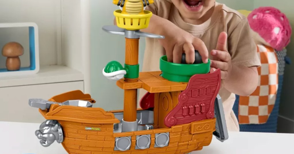Little boy playing with little people pirate ship