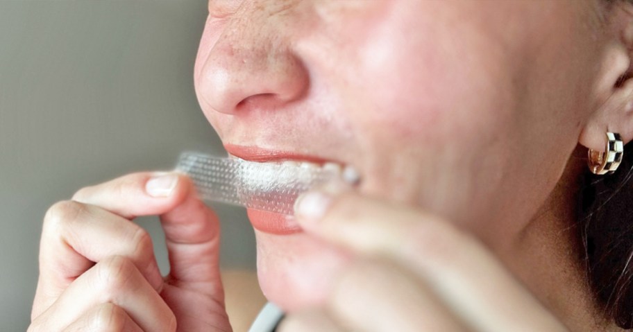 woman applying Lumineux Teeth Whitening Strip