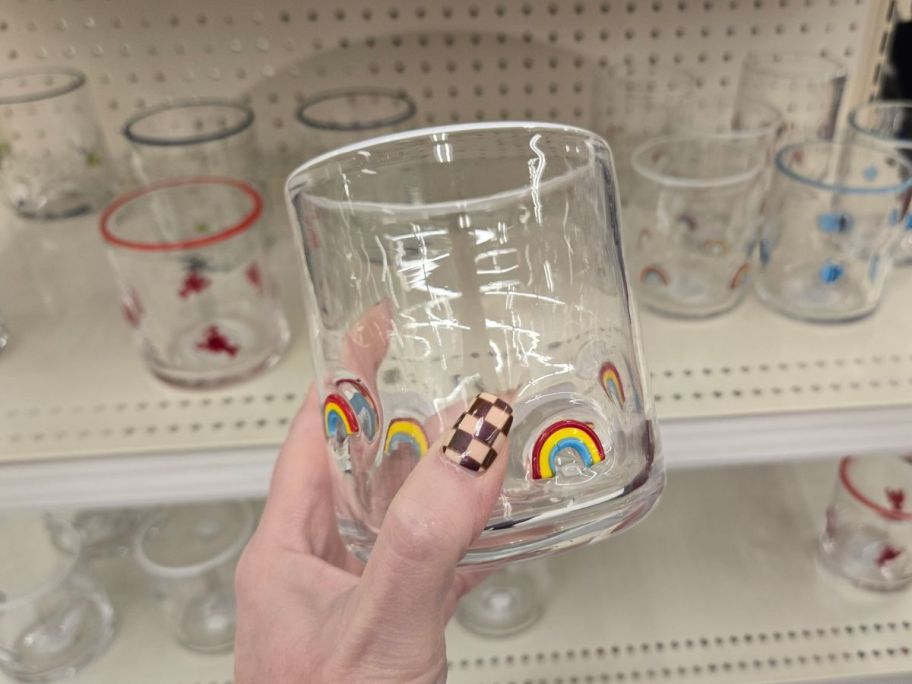  person holding a glass with small rainbow decorations on them 