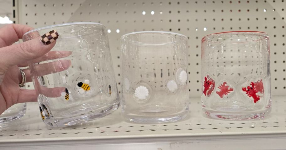 a person touching glasses with small decorations on them 