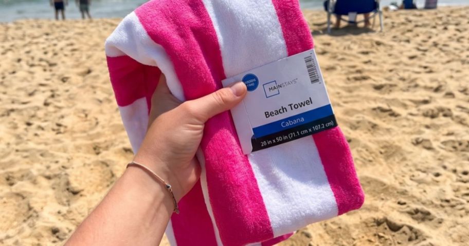 hand holding Mainstays Cabana Stripe Beach Towel on beach
