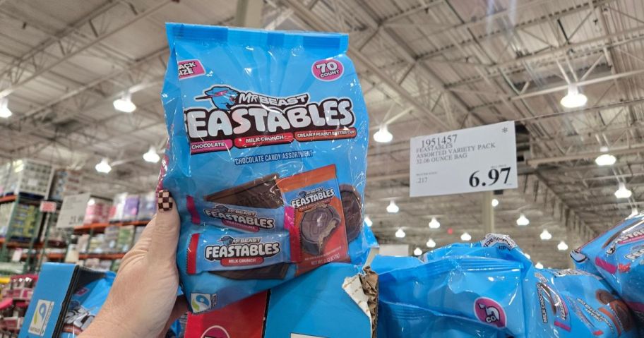 A person holding up a blue bag of Mr. Beast candy