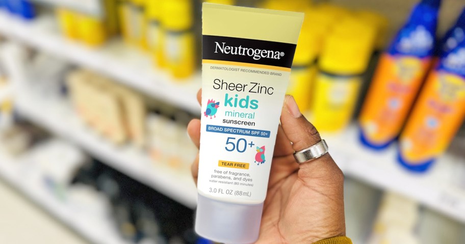 hand holding a tube of Neutrogena Kids Mineral Sunscreen in store