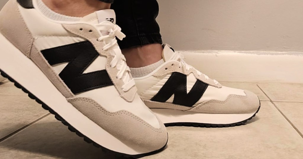 Person wearing black and white new balance sneakers with black pants