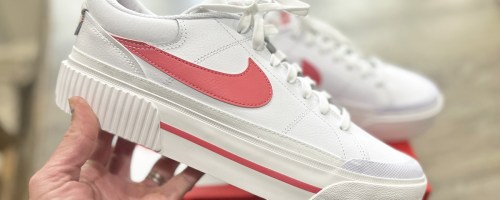 hand holding up white and pink platform nike sneakers