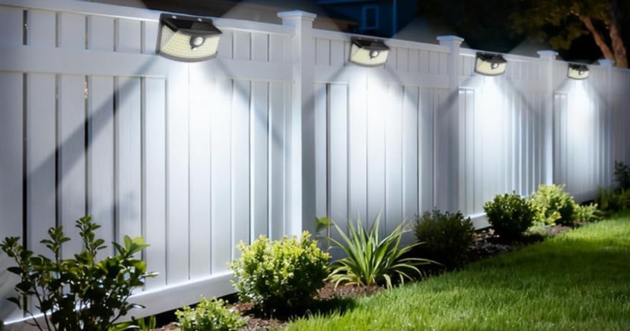 outdoor lights on a white privacy fence.