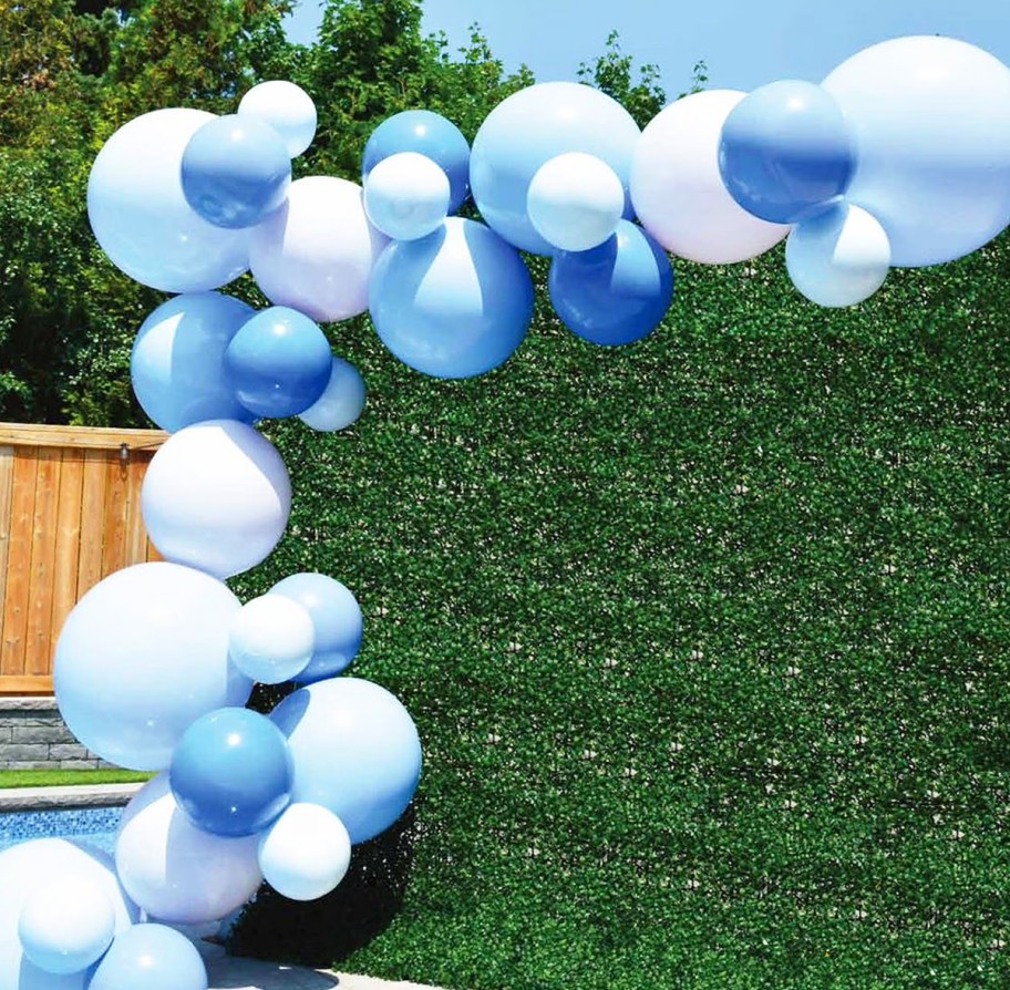 blue balloon garland on a green photo backdrop