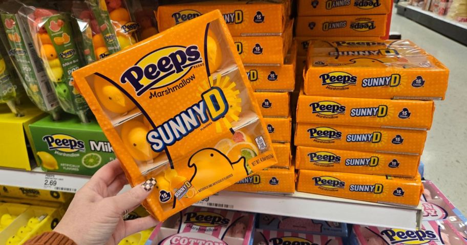 A person holding up a box of Sunny D Peeps candy 