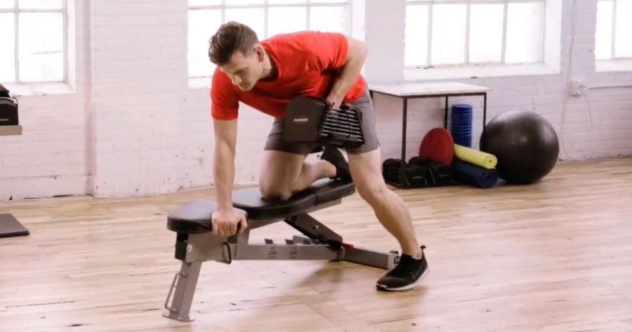 Man leaning on a PowrBlock Bench using PowerBlock adjustable weights