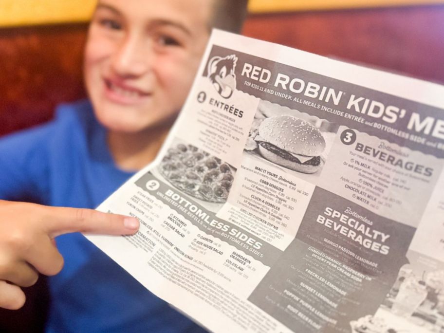 Boy pointing to the bottomless sides on a Red Robin Kids Meal Meni