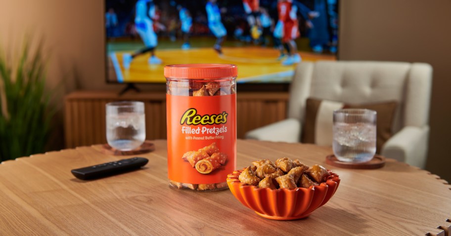 Reese's filled pretzels on table top in front of TV with football game