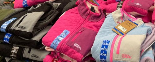Stacks of folded Eddie Bauer Kids Jackets at Sam's Club