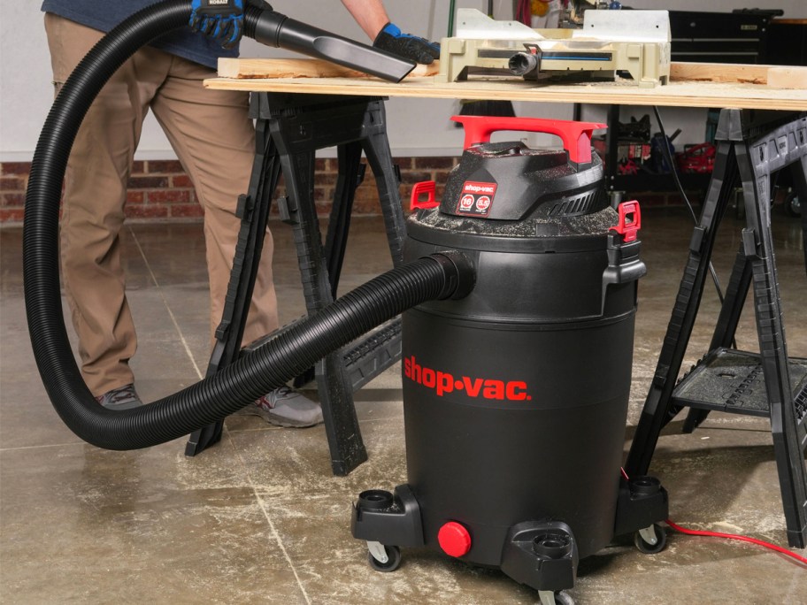 man using a Shop-Vac to clean up garage