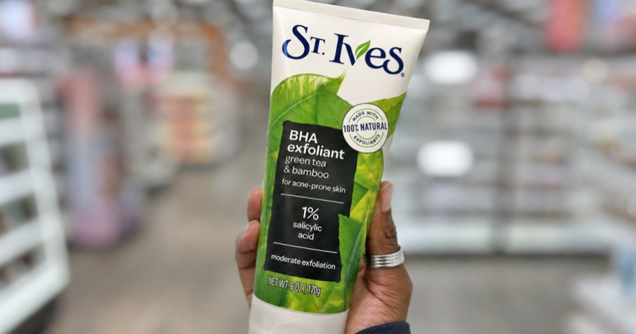 hand holding up a bottle of St. Ives BHA Green Tea & Bamboo Face Scrub in store