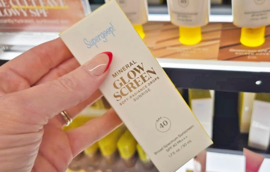 hand holding a box of Supergoop! Glowscreen in store