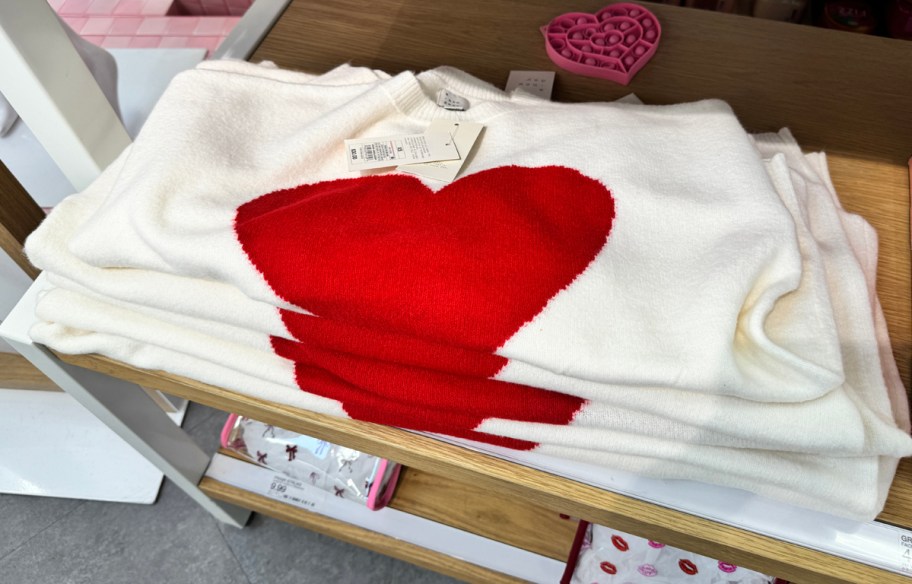 Folded pullover heart sweater on shelf