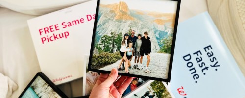 holding a framed family photo above walgreens photo packaging