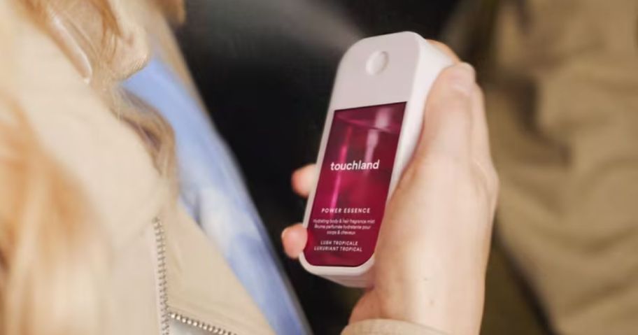 Woman holding a Touchland Body Spray
