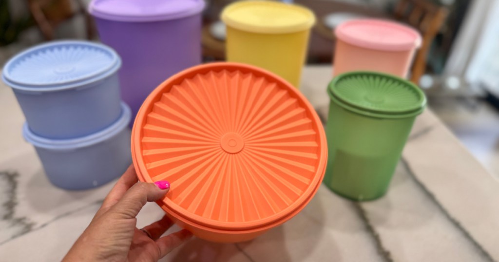 woman holding up orange tupperware container