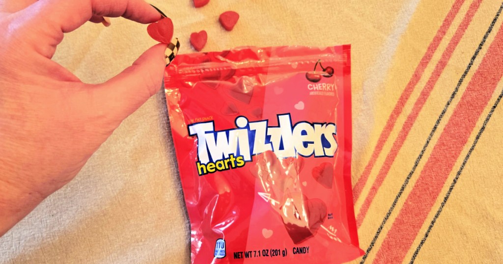 Woman holding up heart shaped Twizzler in front of bag