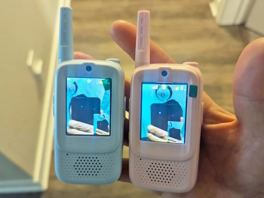 hand holding blue and pink video walkie talkies