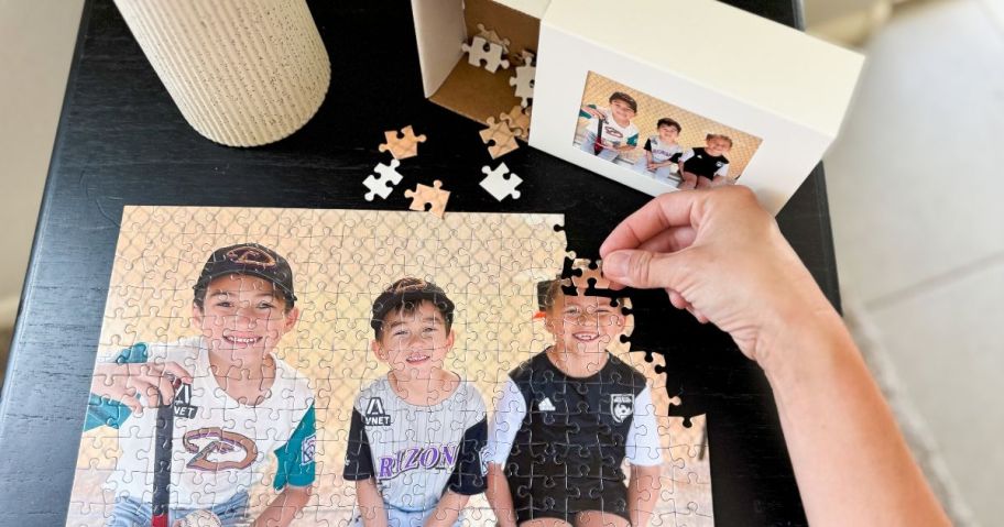 Hand making a Walgreens photo puzzle with children on it