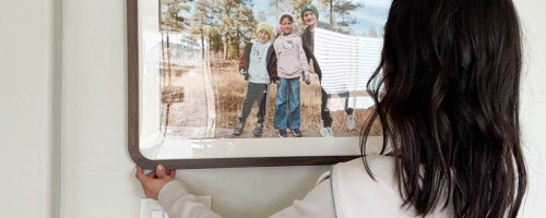 Woman holding up a large framed picture