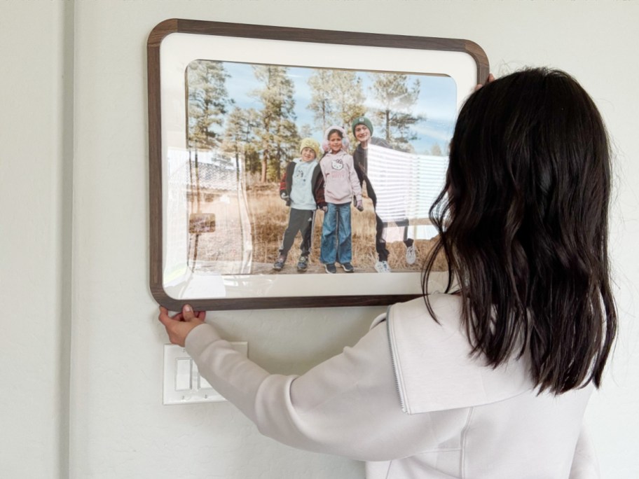 Woman holding a large framed photo