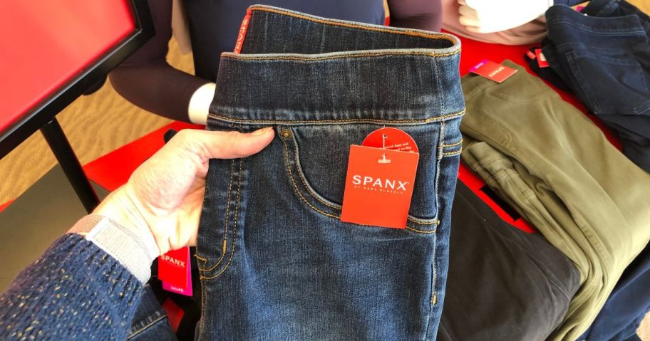 Woman holding Spanx jeans